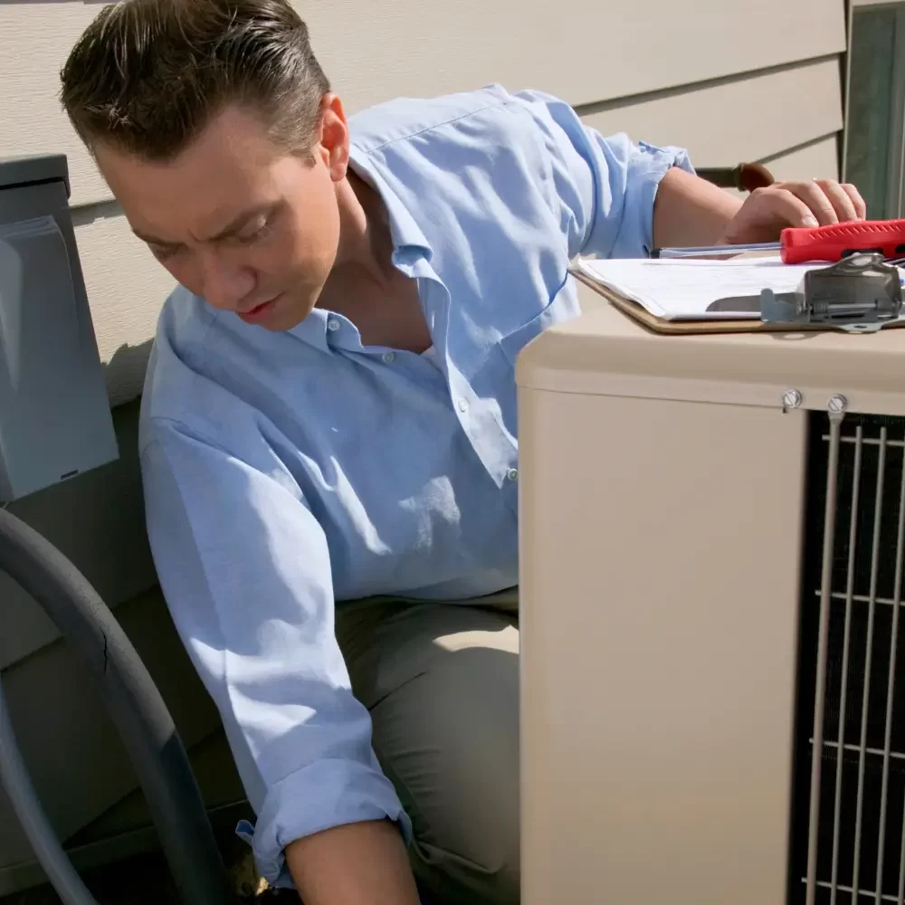 Técnico revisando el compresor de un aire acondicionado doméstico